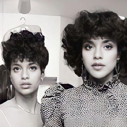 two women with curly hair standing next to each other