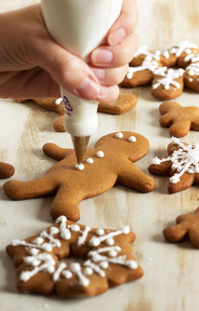 someone is decorating ginger cookies with icing