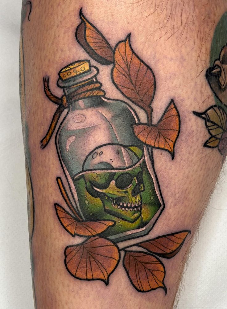 a skull in a glass bottle with leaves around it on the calf's leg