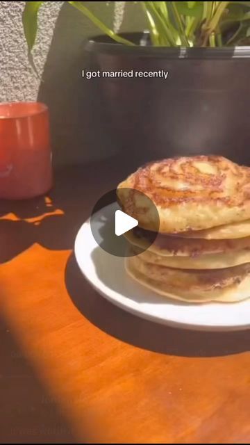 some pancakes are on a white plate near a potted plant and candle with the words i got married recently