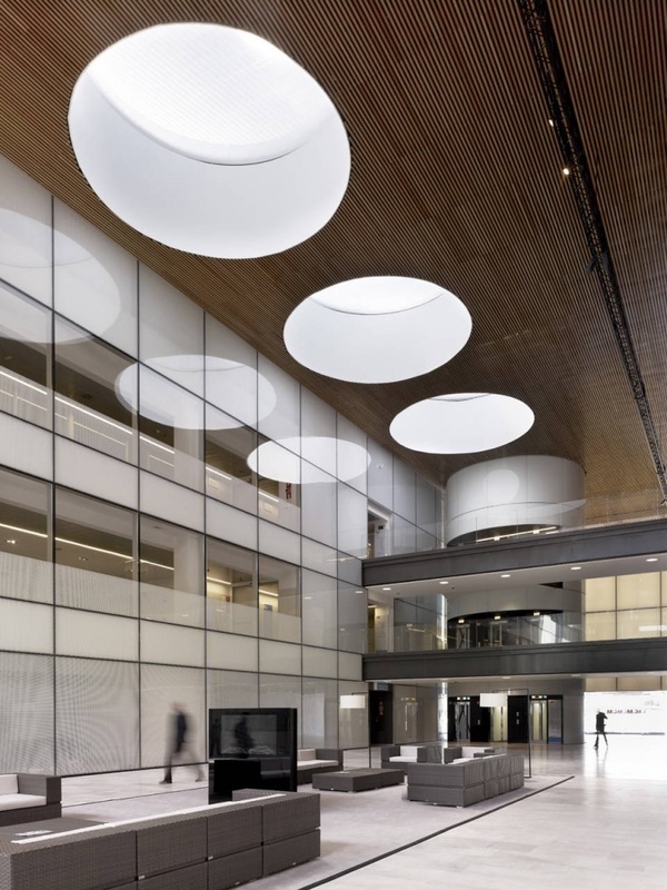 an empty lobby with large mirrors and lights on the ceiling