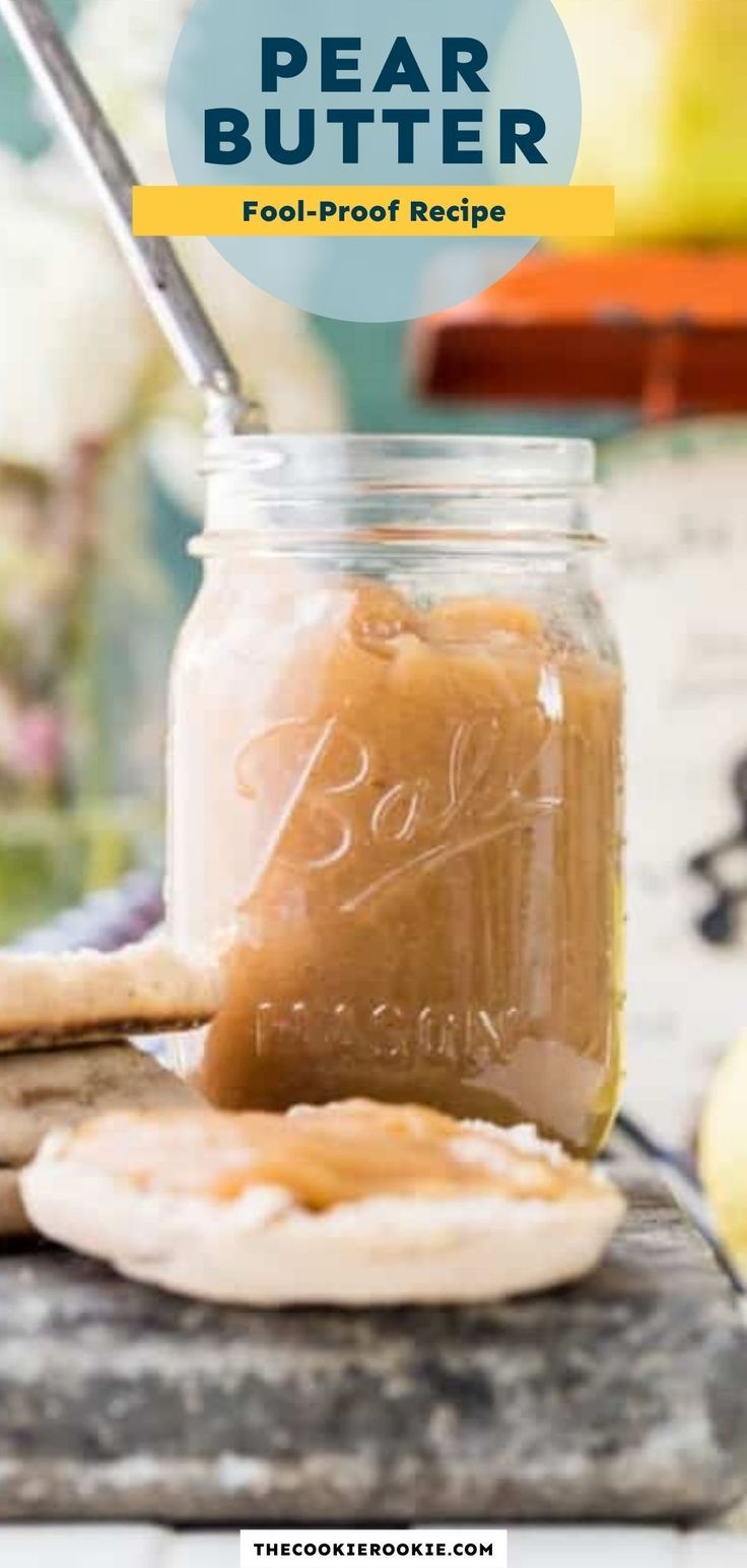 a jar filled with peanut butter sitting on top of a wooden table next to cookies