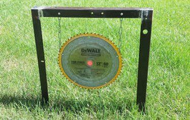 an old record sitting in the grass on top of a wooden stand that is attached to a pole