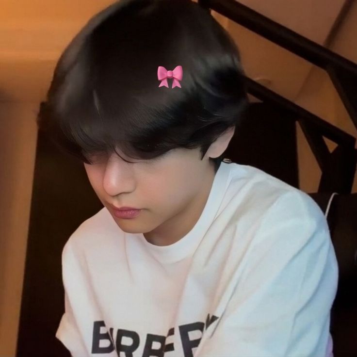 a girl with black hair wearing a pink bow in her hair