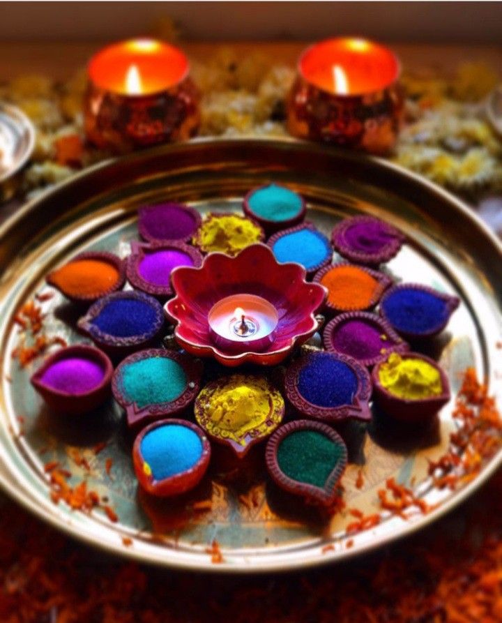 colorful diya with candles on a metal tray