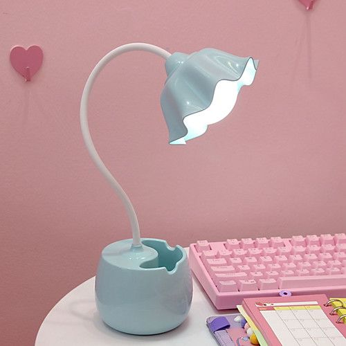 a desk lamp sitting on top of a white table next to a keyboard and mouse