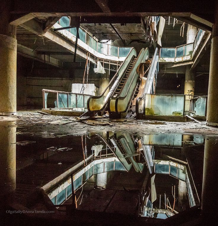 an escalator in the middle of a building with water reflecting it's surface