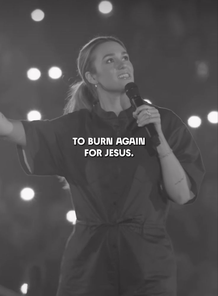 a woman holding a microphone with the words to burn again for jesus