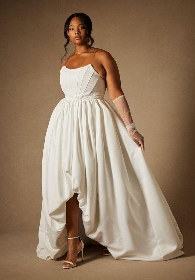 a woman in a white dress posing for the camera with her hands on her hips