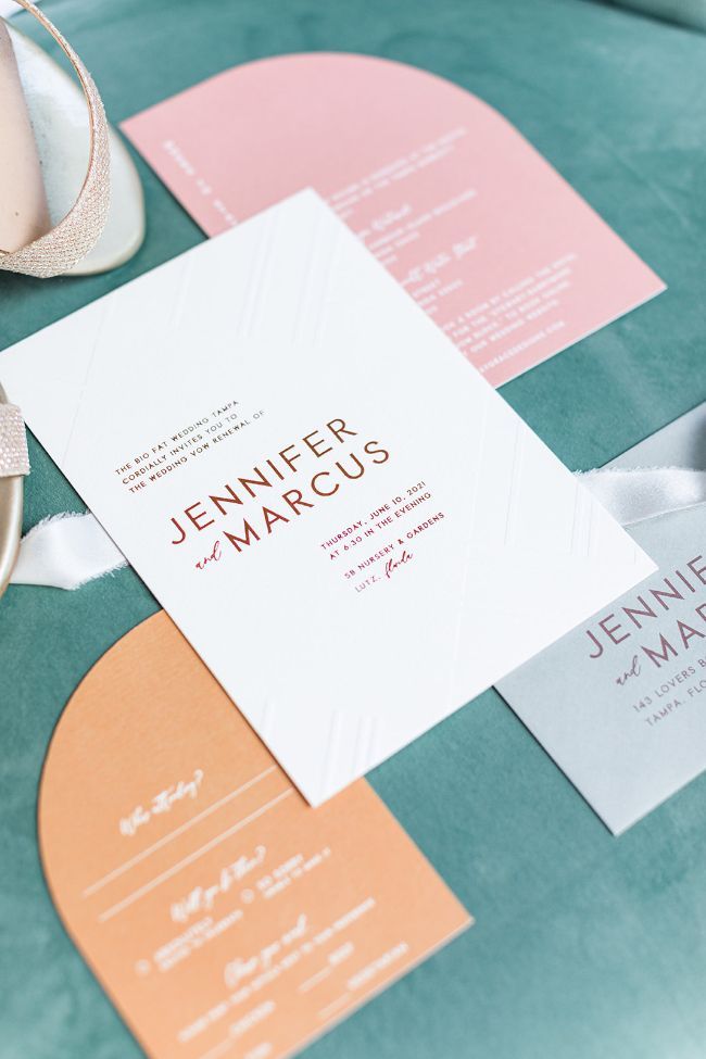 the wedding stationery is laid out on top of the table with shoes and napkins