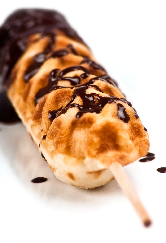 a chocolate covered hot dog on a stick