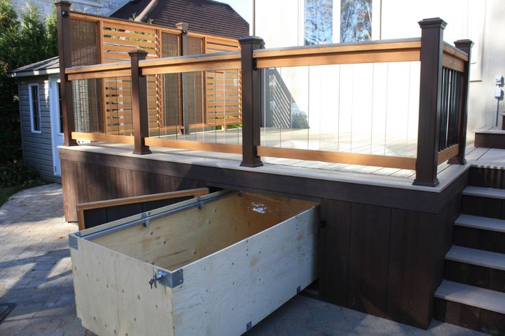 a large wooden box sitting on the side of a house next to stairs and steps