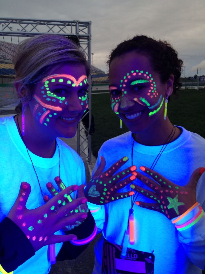 two girls with glow face paint on their hands