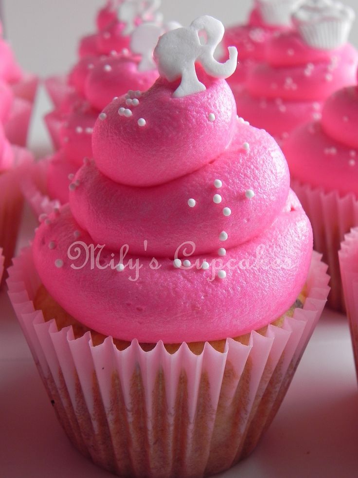 cupcakes with pink frosting and white decorations