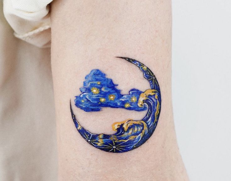 a tattoo on the arm of a person with a blue moon and stars painted on it