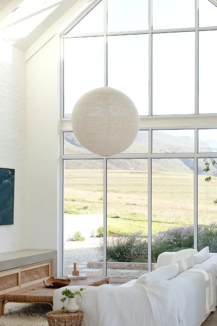 a living room filled with furniture and a large window covered in white cloth coverings