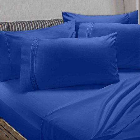 a bed with blue sheets and pillows on it