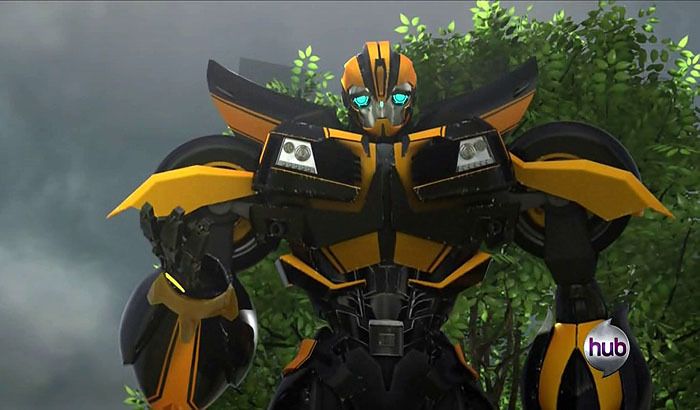 a yellow and black robot standing in front of some trees