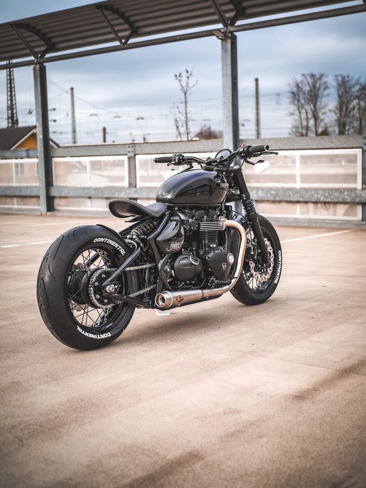 a black motorcycle parked in an empty parking lot