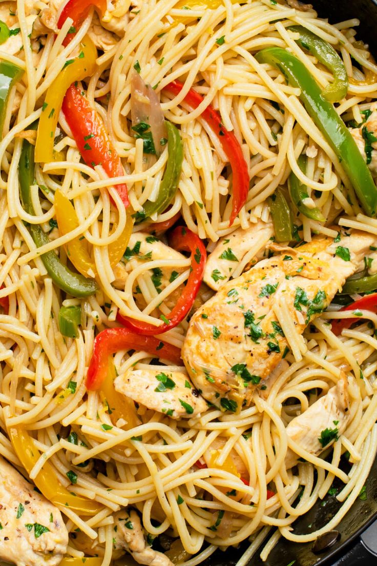 a pan filled with chicken, peppers and noodles