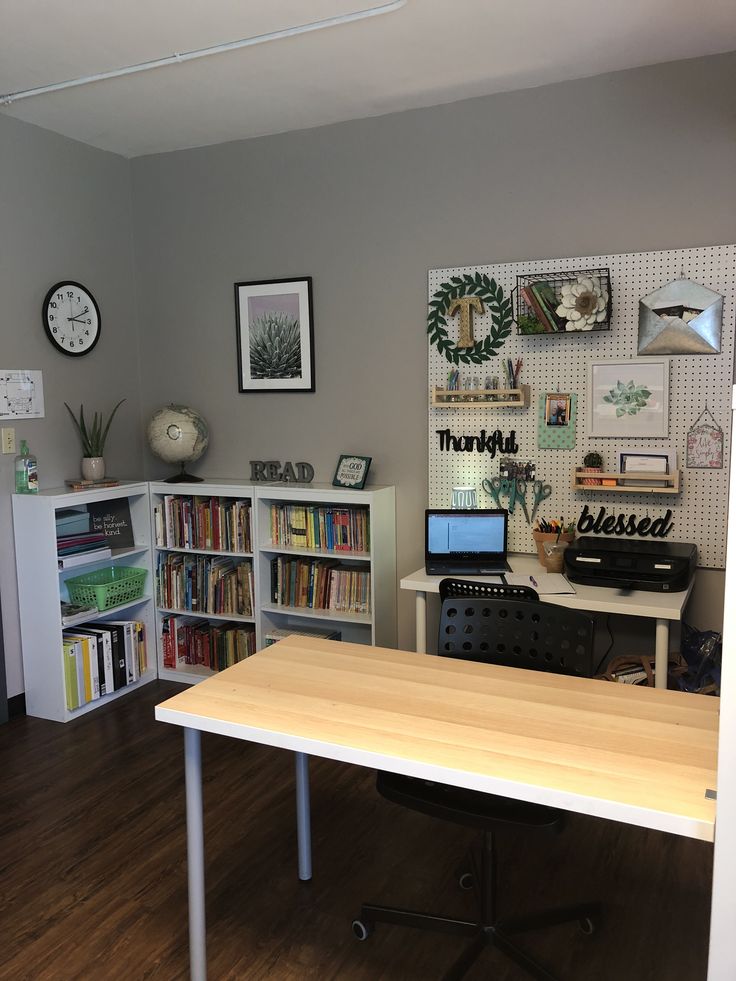 a room with a desk, bookshelf and computer on the table in it