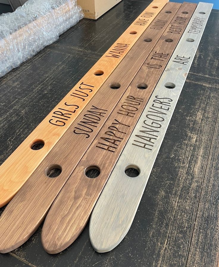 three wooden rulers sitting on top of a table next to each other with words engraved on them