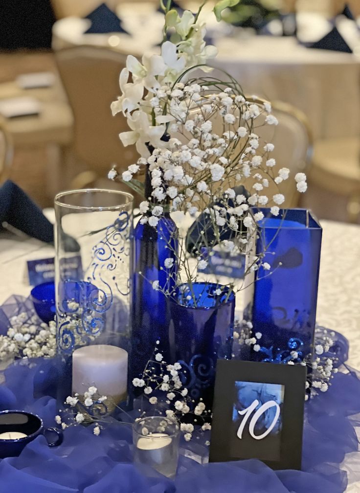 a centerpiece with blue glass vases and white flowers