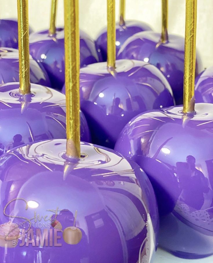 several purple apples with gold candles on them