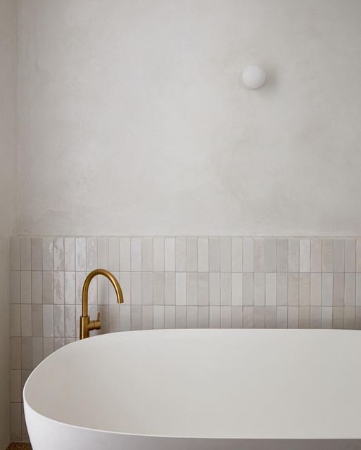 a large white bath tub sitting next to a wall