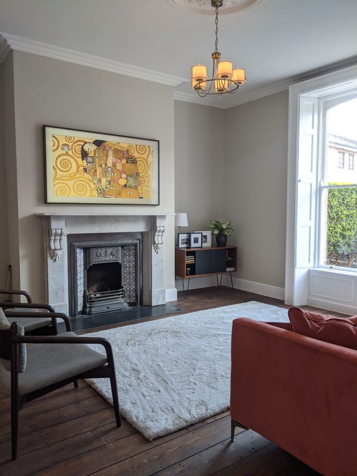 a living room filled with furniture and a fire place next to a painting on the wall