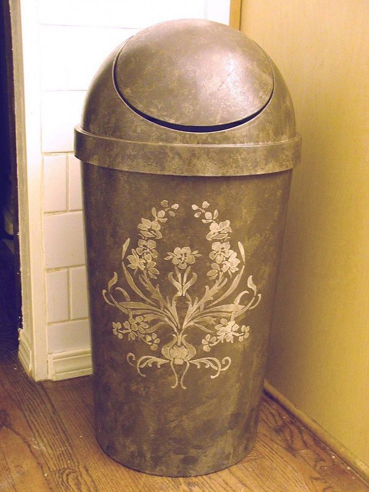 a metal trash can sitting on top of a hard wood floor next to a door