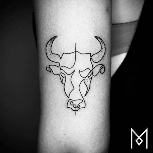 a black and white photo of a bull's head on the left inner arm