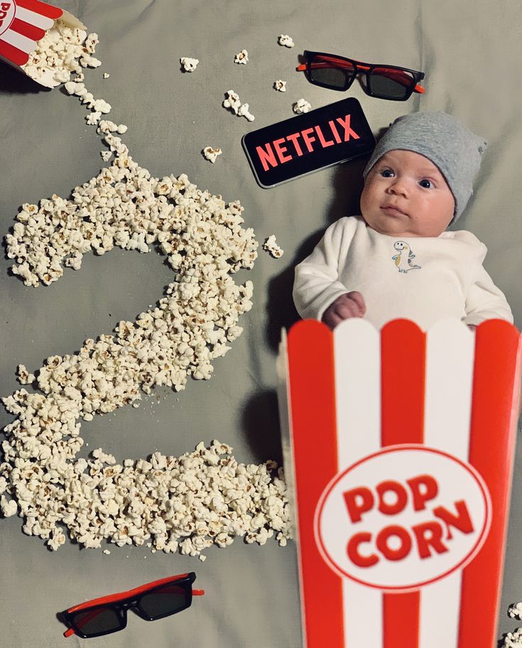 a baby in a popcorn box surrounded by sunglasses