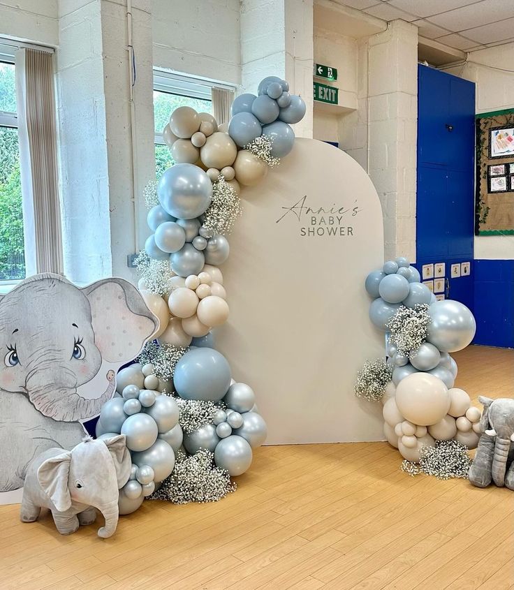 an elephant and baby elephant balloon arch in the middle of a room