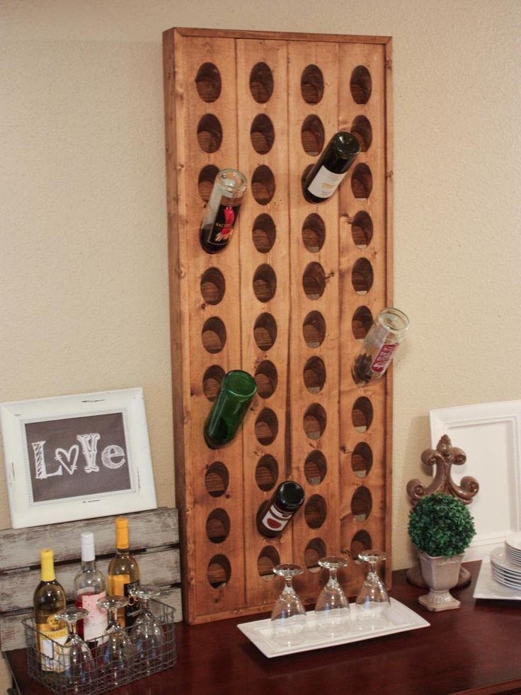 a wooden wine rack sitting on top of a table next to a wall mounted bottle opener