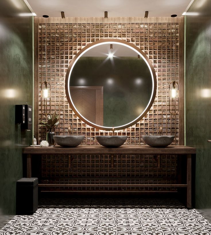 a bathroom with two sinks and a round mirror