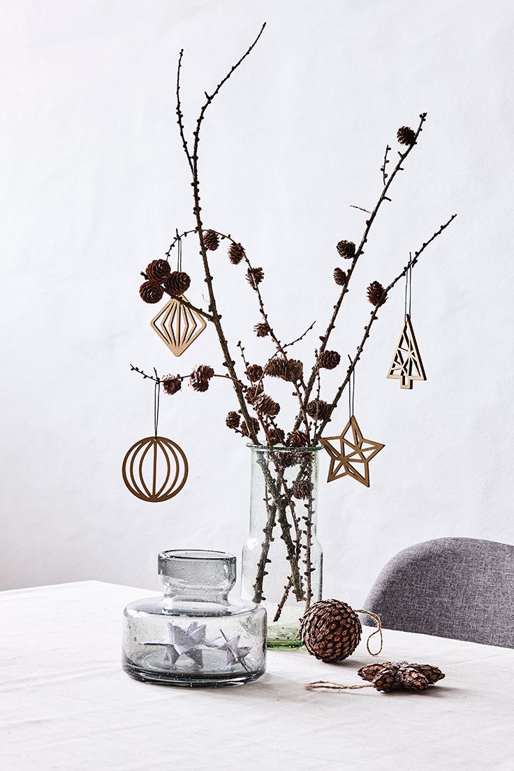 a vase filled with branches and ornaments on top of a table