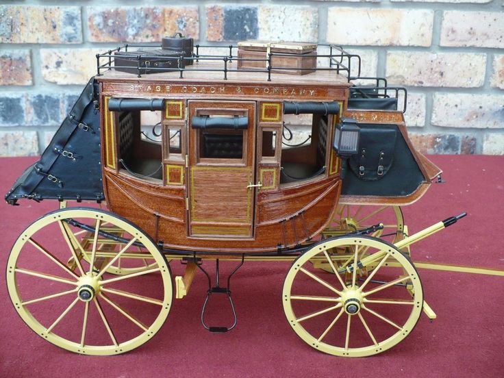 an old fashioned wooden carriage on display in front of a brick wall and red carpet