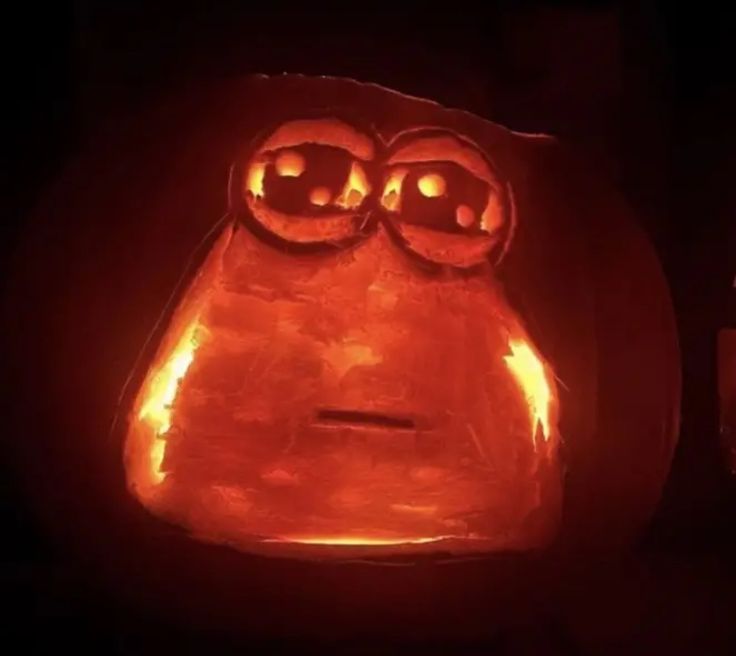 a pumpkin with an angry face carved into it's side and eyes glowing in the dark