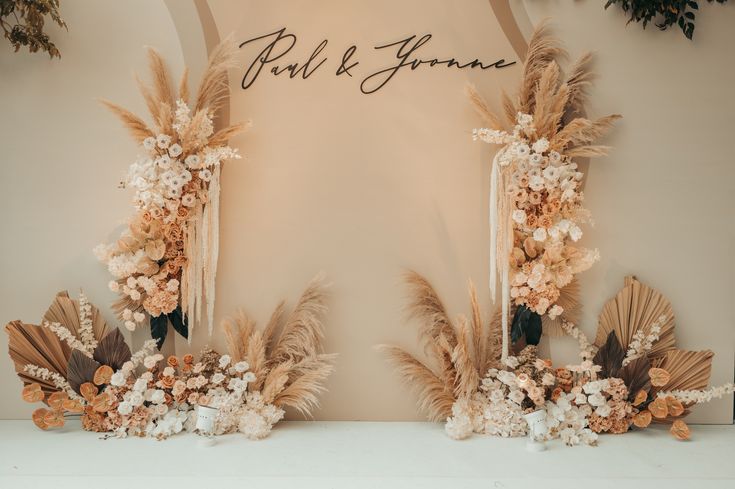 two mirrors with flowers and feathers in front of a sign that says paul & june