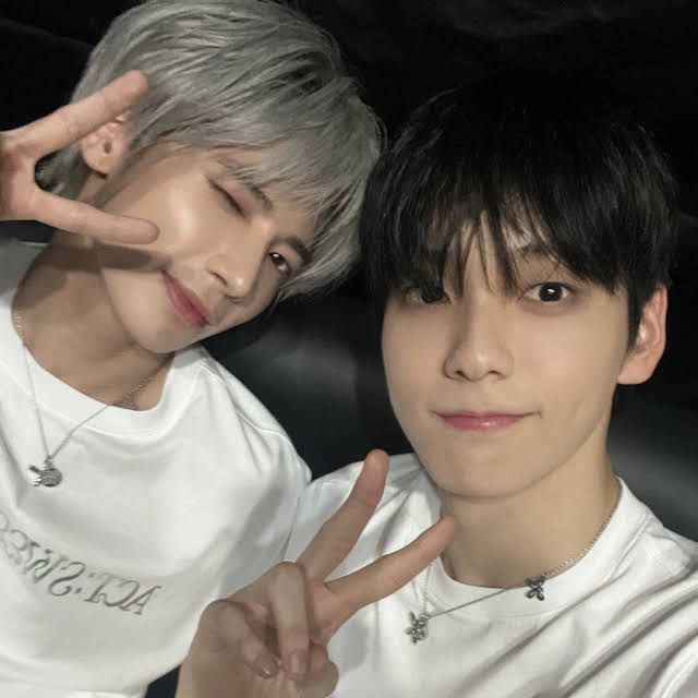 two young men posing for the camera with their fingers in the shape of peace signs