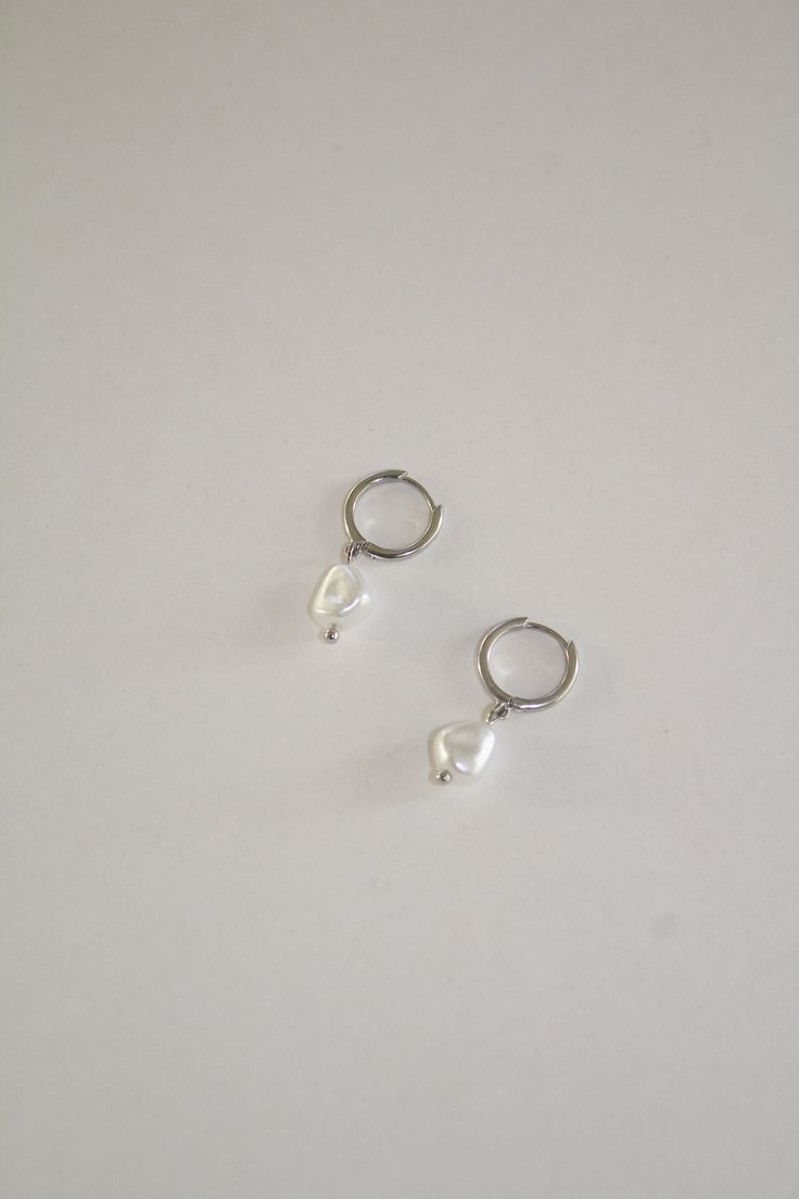 Description Gold clasp hoops with a hanging pearl. Material Sterling Silver 925 Care Remove before showering, sleeping, or any activities that may result in contact with moisture or friction. Sterling silver is soft and flexible, so if your earring post needs a little adjusting, it is totally normal. Clean after every use with the cloth provided to keep them looking new Lastly, store your pieces when not wearing them to avoid any damage. Silver Huggie Pearl Earrings For Everyday, Everyday Sterling Silver Huggie Pearl Earrings, Minimalist Sterling Silver Huggie Pearl Earrings, Silver Small Hoop Pearl Earrings For Everyday, Silver Small Hoop Pearl Earrings, Silver Pearl Drop Huggie Earrings As Gift, Silver Minimalist Pearl Charm Earrings, Minimalist Silver Pearl Earrings With Charm, Everyday Hoop Earrings With Pearl Charm In Sterling Silver