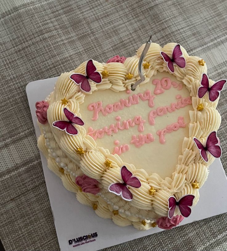 a heart shaped cake with pink butterflies on it