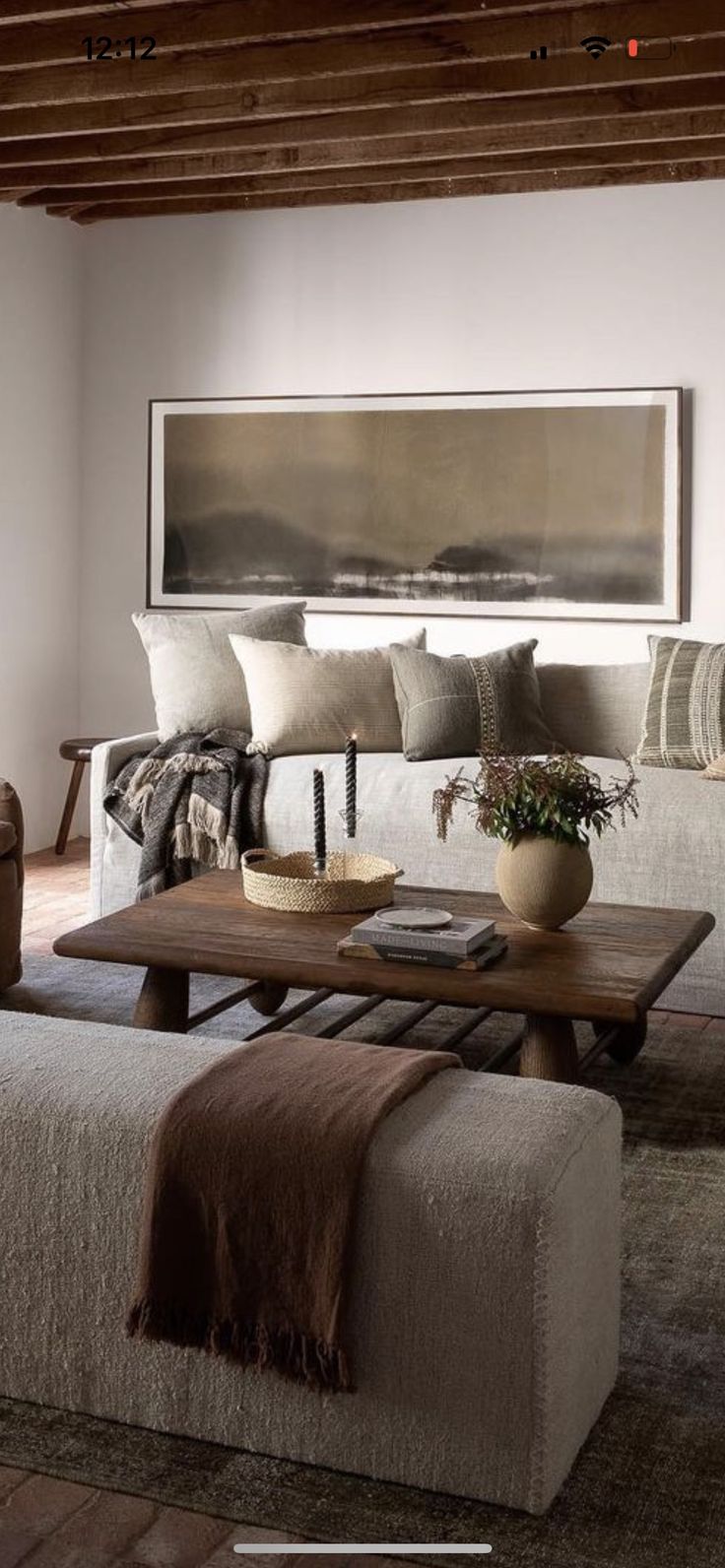 a living room filled with furniture and a large painting on the wall above the couch