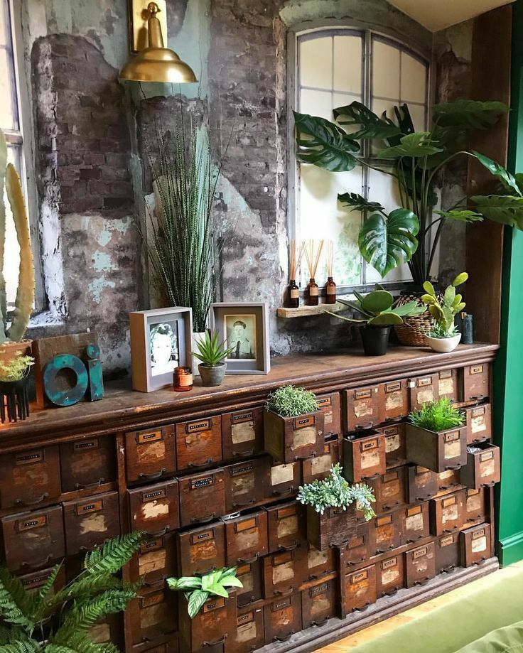 a room filled with lots of wooden drawers and plants