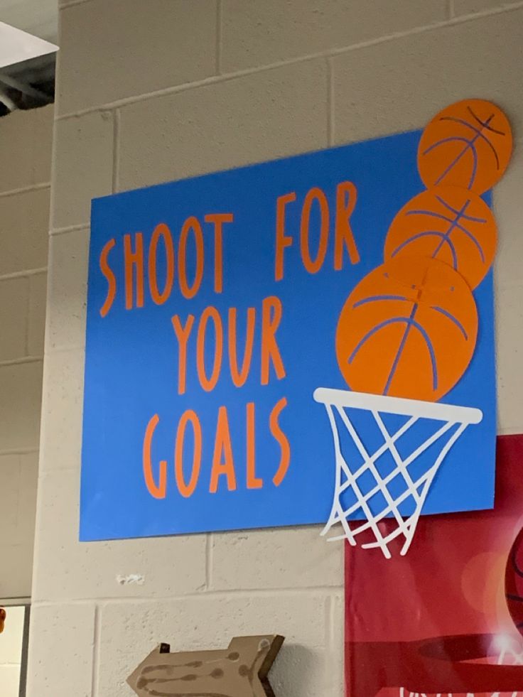 there is a sign on the wall that says shoot for your goals and basketballs