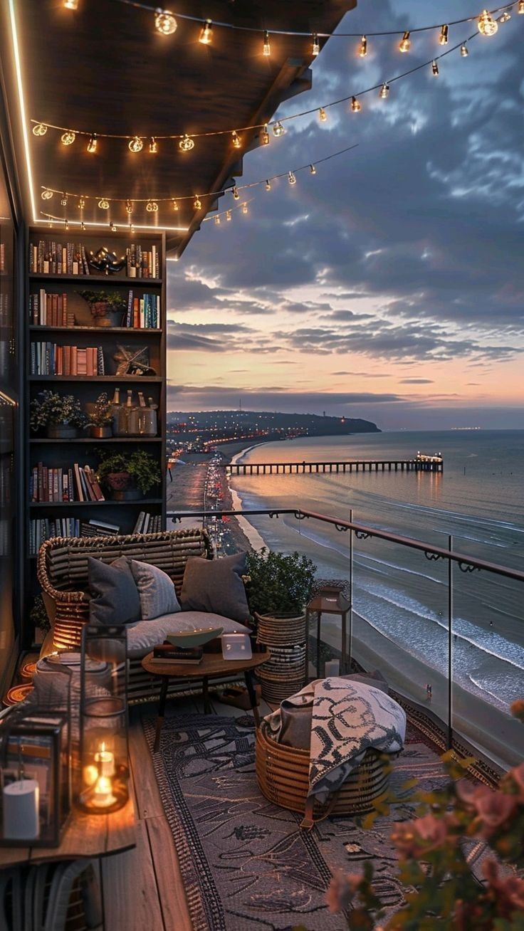 the balcony is decorated with wicker furniture and string lights, along with an ocean view