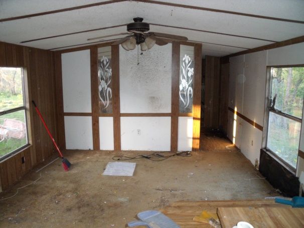 an empty room with wood paneling and windows