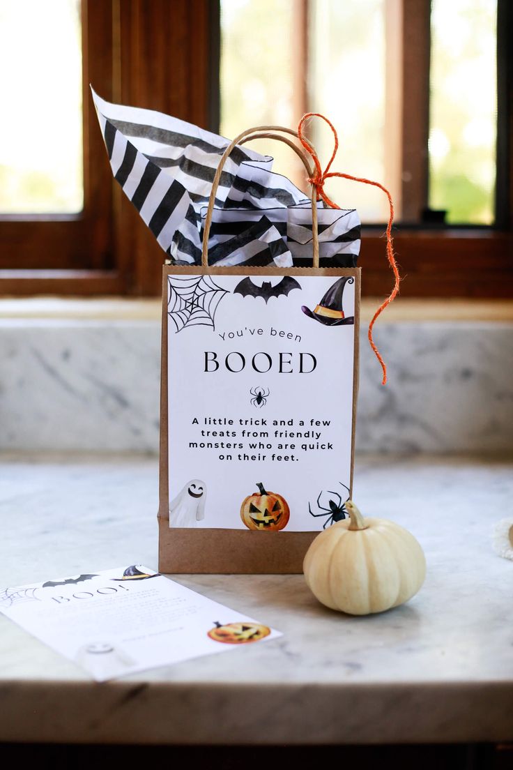 a halloween treat bag sitting on top of a counter next to a pumpkin and spider web