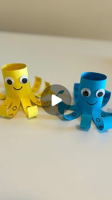 two paper cups with googly eyes and arms made to look like octopus's